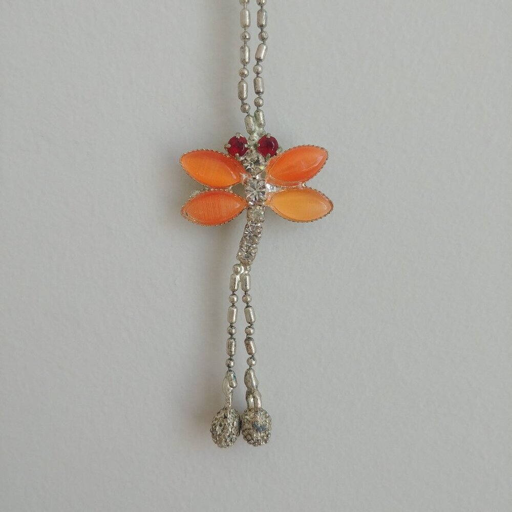 Short silver tone necklace with red orange dragonfly pendant